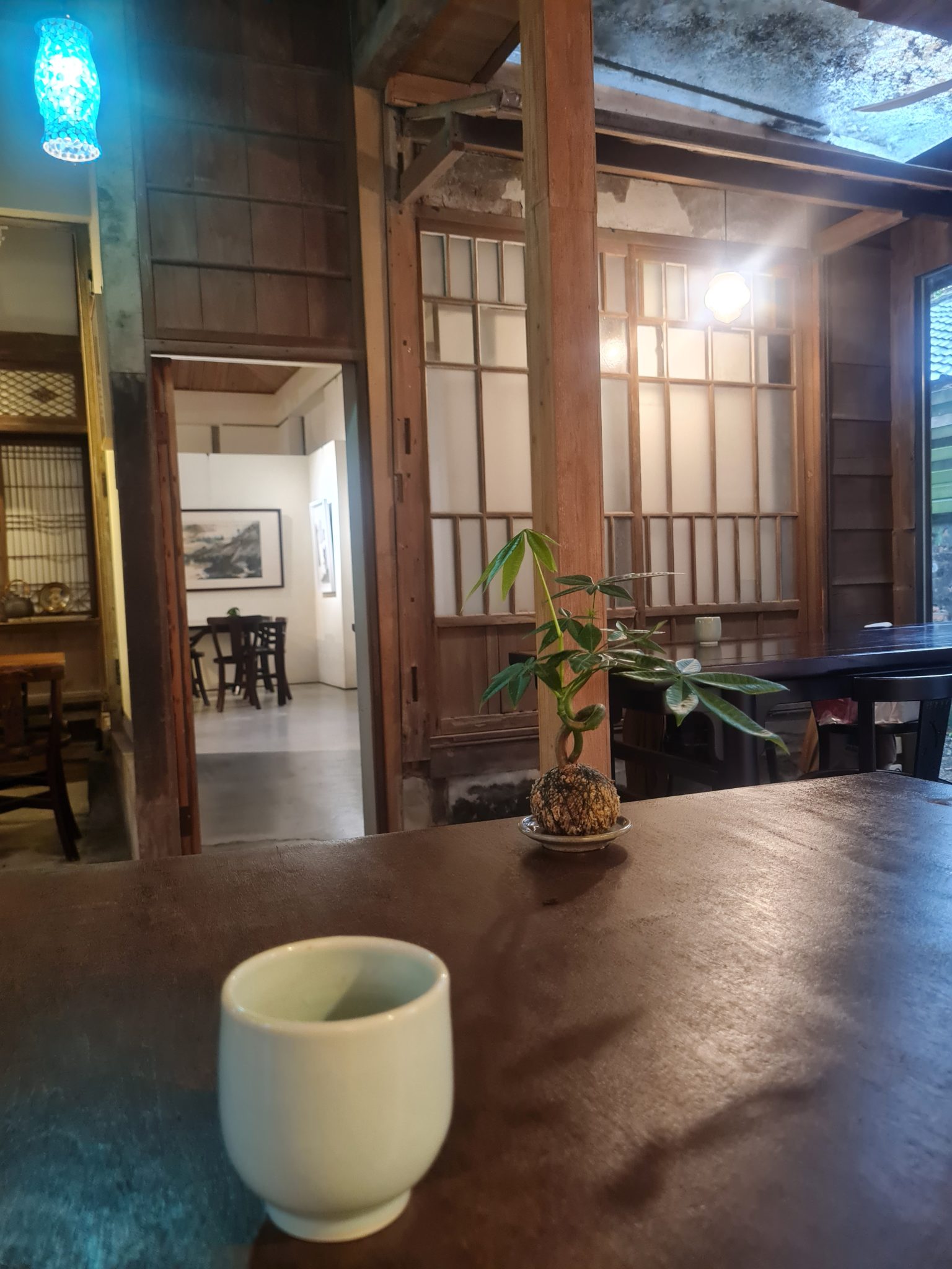 Wood-lined Japanese dining interior with table seating and soft lantern light